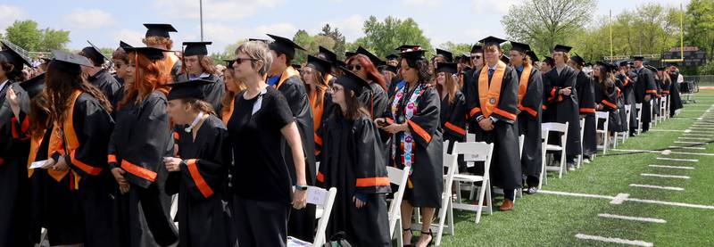 Graduates stand Saturday, May 20, 2023, during the McHenry Community High School Graduation Ceremony for class of 2023 at McCracken Athletic Field in McHenry.