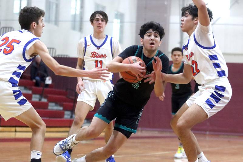 Woodstock North’s Cesar Ortiz navigates through heavy traffic against Fenton during 72nd Annual E.C. Nichols Holiday Classic Basketball Tournament action at Marengo High School Thursday. From left, Fenton’s Brandon Block, Damian Harnish and Alejandro Diaz defend.