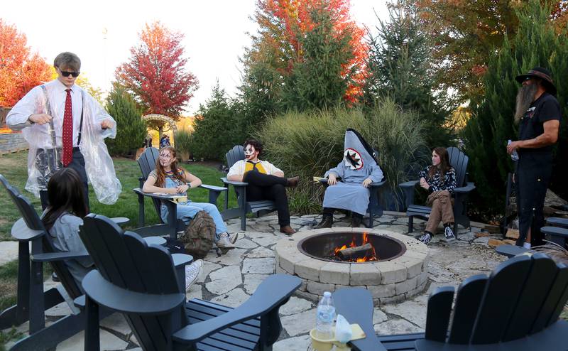 Participants in the Kamme-O-Circus Halloween Party chat by a campfire on Saturday, Oct. 19, 2024 in Elburn.