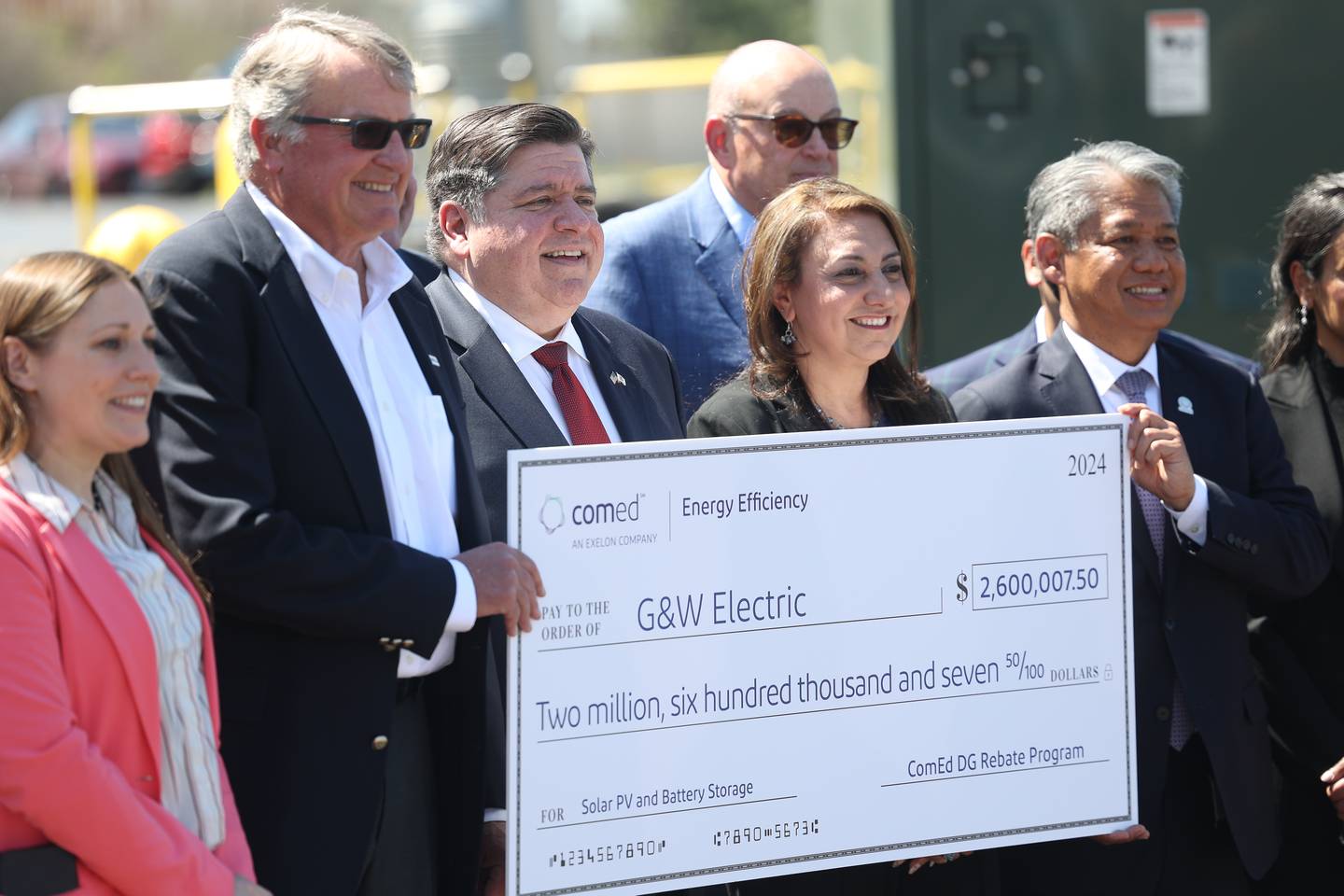 John Mueller, chairman, and owner of G&W Electric, and Gov. J.B. Pritzker, and others attend an event outside the G&W Electric building in Bolingbrook.