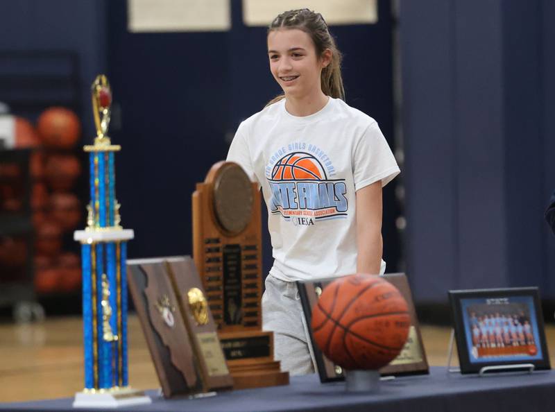 Kinley Gruber, smiles while walking past the trophy table Members during a prep rally on Thursday, Dec. 11, 2025 at Bureau Valley High School in Manlius. The Storm (23-1) will meet undefeated Mt. Sterling Brown County (25-0) for the IESA Class 2A state title at 7:30 p.m tonight.