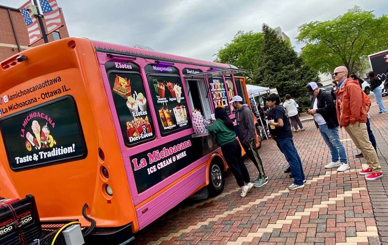 A crowd lines up to score some sweets from La Michoacana Ice Cream food truck on Sunday, May 4, 2025, in the Frank Van Buer Plaza in downtown DeKalb for the city's annual Cinco de Mayo Celebration.
