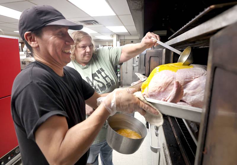 Gustavo Lepez, (left) kitchen supervisor for the Voluntary Action Center, and Amy Woods, kitchen manager, prepare turkeys for the oven as part of Thanksgiving meals Thursday, Nov. 17, 2022, at the facility in Sycamore. The Thanksgiving meals were payed for through a donation from the family of Don "Tank" Anderson. VAC delivers meals to the homebound and elderly along with providing transportation options.