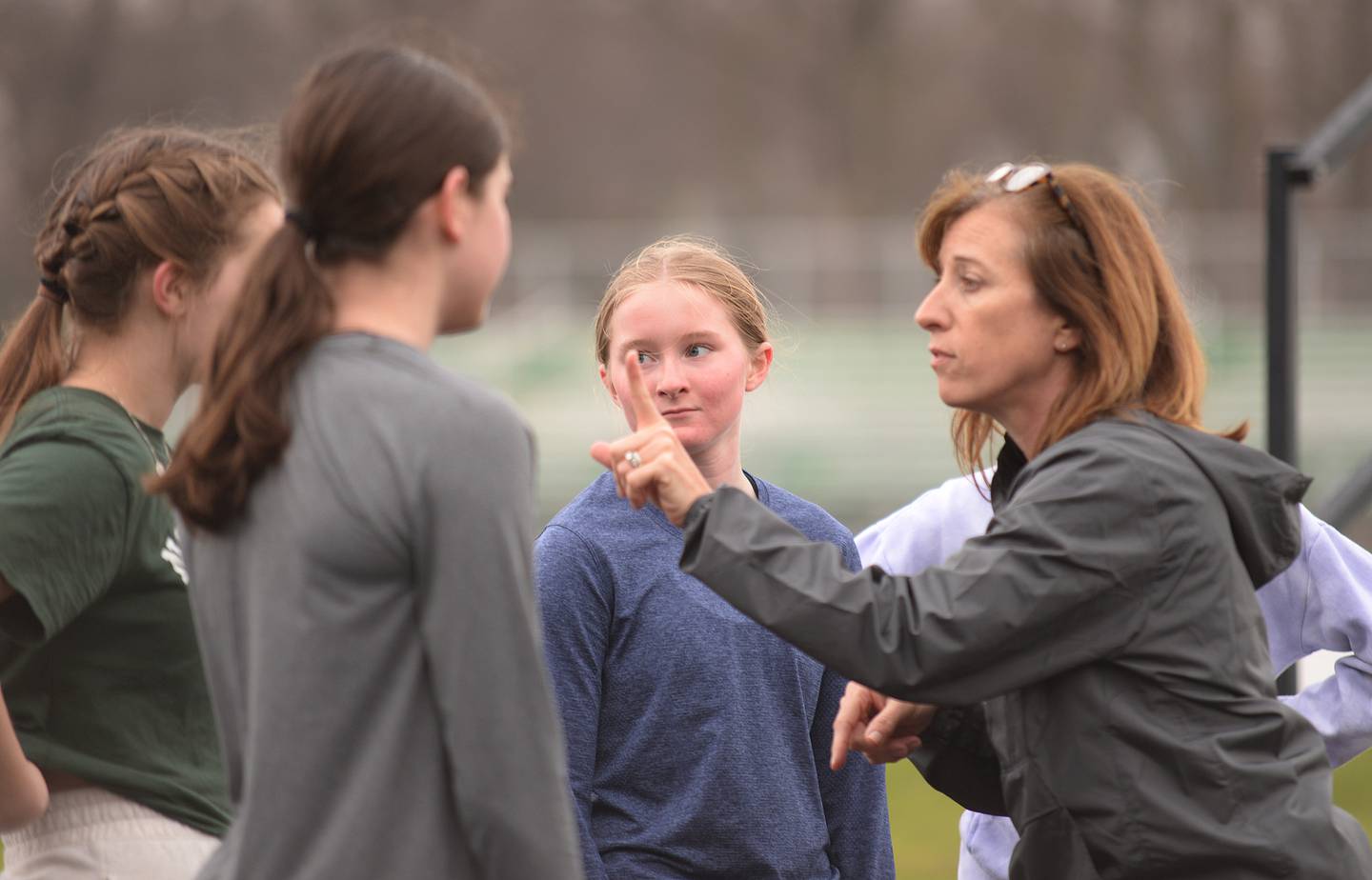 Glenbard West track and cross country coach Kelly Hass gives her team guidance during  practice Friday March 31, 2023.