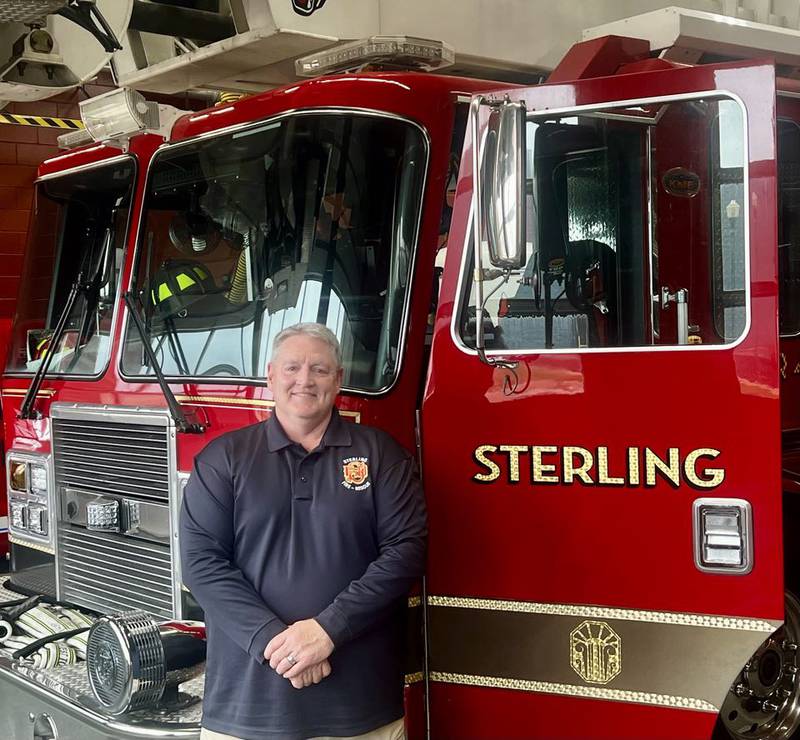 Newly appointed Fire Chief David Northcutt stands besides a fire engine at the Sterling Fire Department.