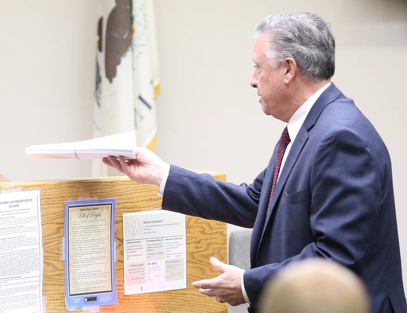 Paul De Luca, hands Visiting Judge William Dickenson papers during the Mason Shannon trial at the La Salle County Governmental Complex in Ottawa.
