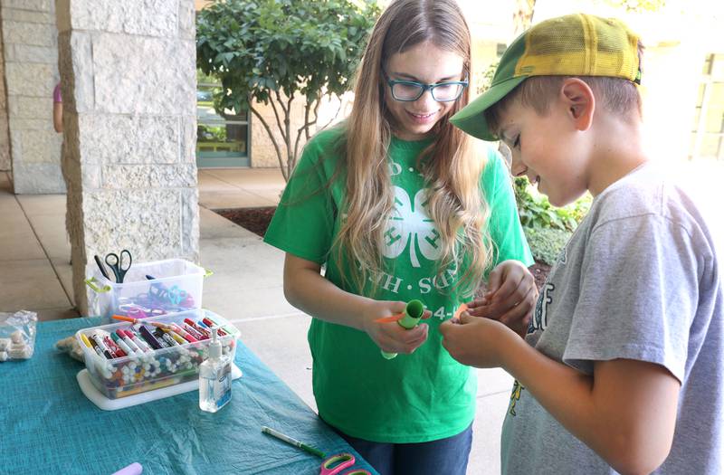 4-H Volunteer Lillian Hetland, 14, from Clare, helps her brother Samuel, 11, build a rocket during the 4-H General Project Show Thursday, July 14, 2022, at the DeKalb County Farm Bureau in Sycamore.