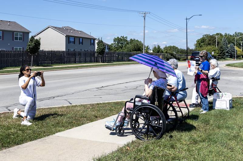 Sharon Griffin takes a video of participants during the ‘Workers Over Billionaires’ Labor Day Protest on the 1100 block of N. River Rd. in Shorewood, IL, on Sept. 1, 2025.