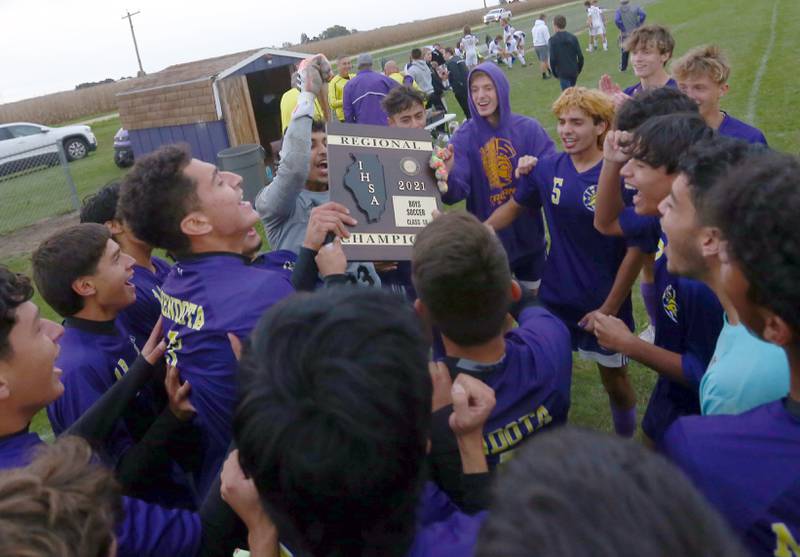 The Mendota boys soccer team holds its Class 1A regional championship plaque after defeating Serena 5-1 during the Class 1A regional final game in Serena on Friday, Oct. 15, 2021.