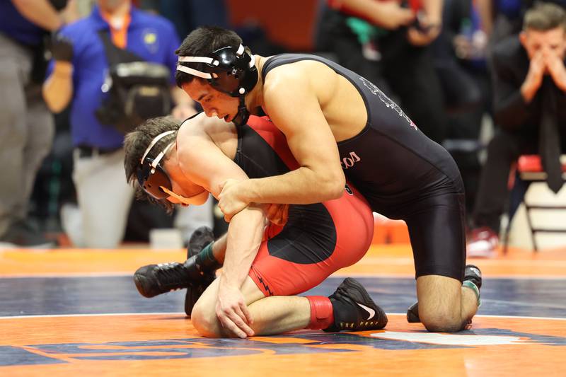 Montini’s Josh Vazquez works over Triad’s Colby Crouch in the 126-pound Class 2A state championship match on Saturday, Feb. 17th, 2024 in Champaign.