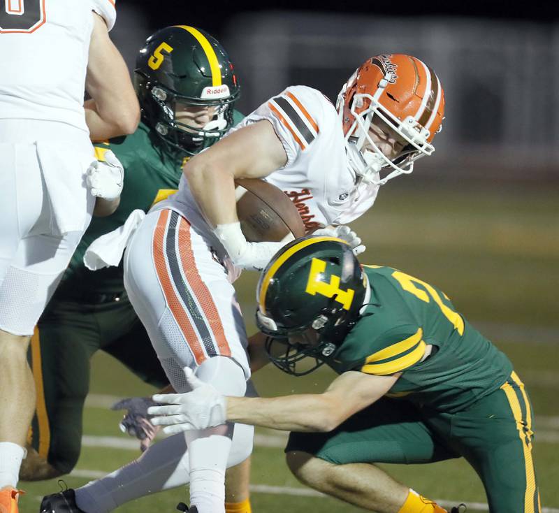 Fremd's Brasyn Turner (5) and Mason Messner (23) wrap up Hersey's Carson Grove (8) Friday September 1, 2023 in Palatine.