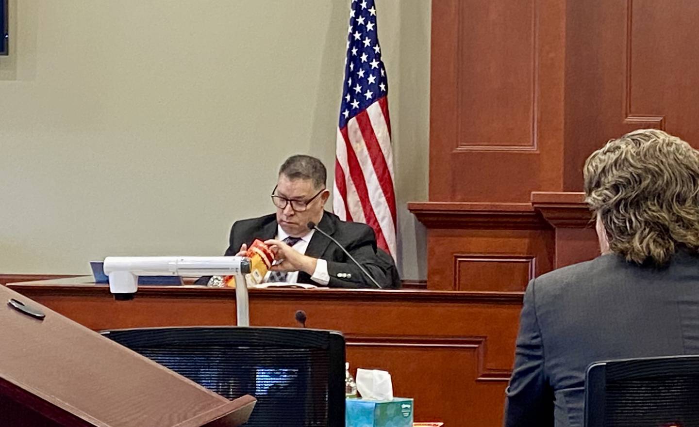 Former DeKalb Police Detective Angel Reyes pulls a fingerprint sample from an evidence bag during witness testimony as lead prosecutor Scott Schwertley watches on Friday, Jan. 24, 2025, during Day 2 of the double murder trial of Jonathan D. Hurst, 55, formerly of Chicago, charged with murder in the 2016 killings of Patricia Wilson and her son Robert Wilson, of Sycamore. The trial convened at the DeKalb County Courthouse.