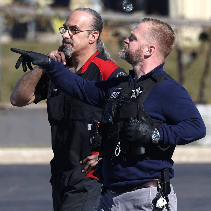 A DeKalb Police officer talks to a Brian Bemis Toyota employee Wednesday, Oct. 23, 2024, outside the dealership in DeKalb after responding to a stabbing where multiple employees were injured. The incident ended after police shot the man wielding the knife authorities said.