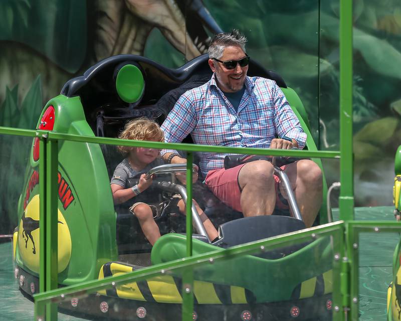 A father enjoys a ride with his son at the Downers Grove Rotary GroveFest in downtown Downers Grove. June 24, 2023.