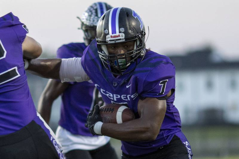 Plano's Carnell Walls runs through a hole during Friday's game with Manteno in Plano.