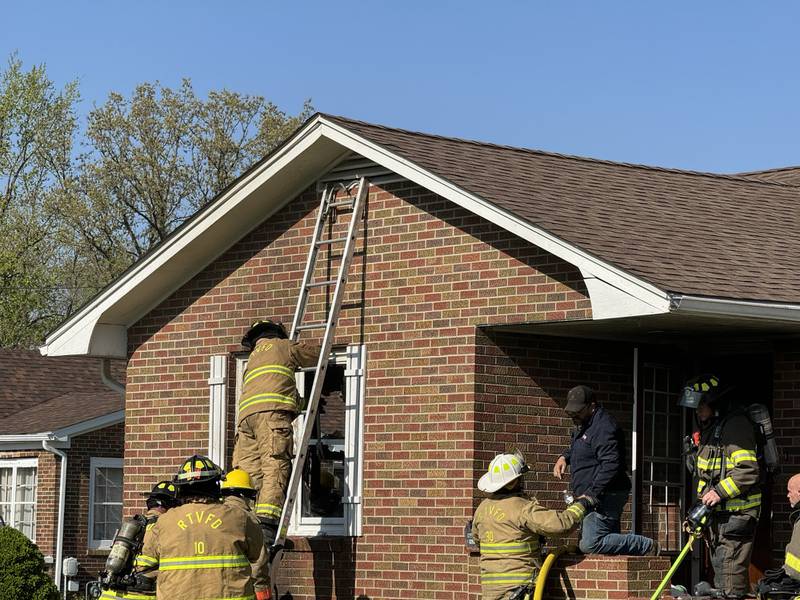 A Reading volunteer firefighter climbs a ladder while fighting a fire at 1621 S. Bloomington St. in Streator on Wednesday, April 24, 2024.