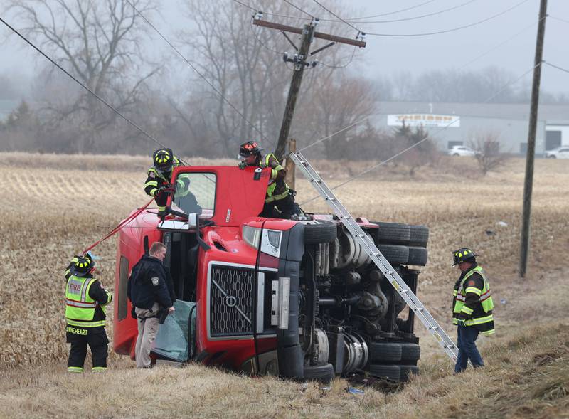 Cortland firefighters and police work to secure the cab of a semitrailer that rolled into the ditch Wednesday, Jan. 7, 2026, on the north side of Lincoln Highway in Cortland.