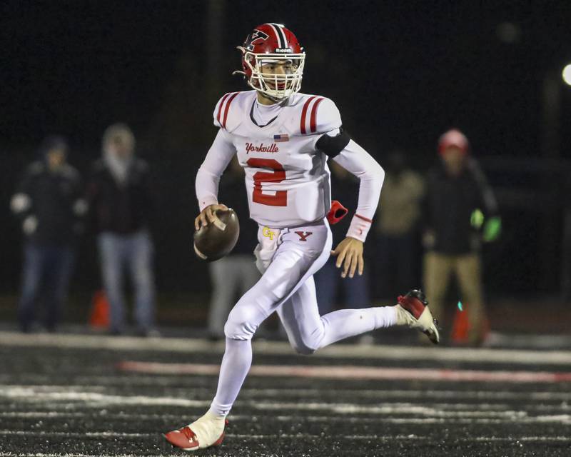 Yorkville's Jack Beetham (2) rolls out while looking for an open receiver during football game between Yorkville at Bolingbrook Friday, Oct 24, 2025 in Bolingbrook.