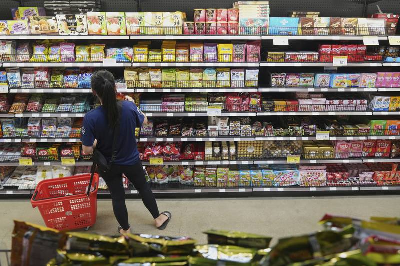FILE - A customer buys Chinese made ginger candy at 99 Ranch Market, an Asian grocery store in Los Angeles, April 7, 2025. (AP Photo/Damian Dovarganes, File)