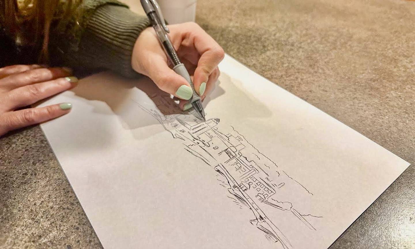 Ashley Klockenga works on the design for the St. Charles mug while staying in the city in April 2023.