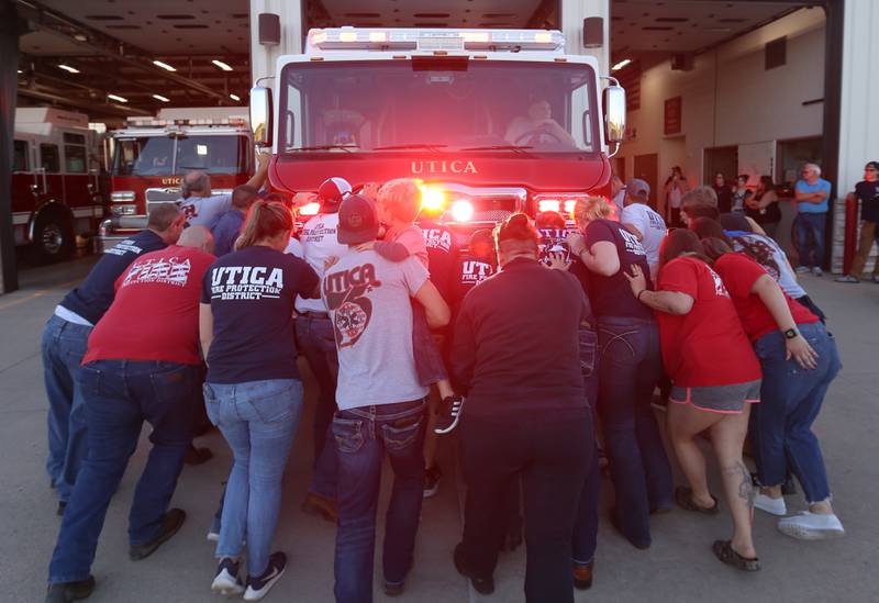 Utica firefighters, push in a new Pierce Heavy Duty Rescue Truck into the bay as firefighter Dennis Hamilton backs the vehicle up at the Utica Fire Station on Thursday, Sept. 14, 2023. It's a tradition for the Utica Fire Department to push in a new fire truck into the bay. The $706,000.00 truck will replace a 28 year old rescue truck. The new vehicle will have equipment to handle water rescue, industrial accidents and grain bin emergencies. The department hopes to have it in operation on Columbus Day weekend.