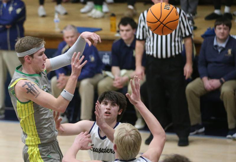 Seneca's Paxton Giertz passes the ball over the heads of Marquette's Griffin Dobberstein and Luke McCullough on Friday, Feb. 21, 2025 in Bader Gym at Marquette Academy.