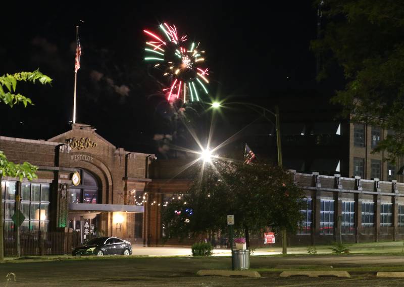 Fireworks glow above the Westclox building on Wednesday, July 3, 2024 along Water Street in Peru.