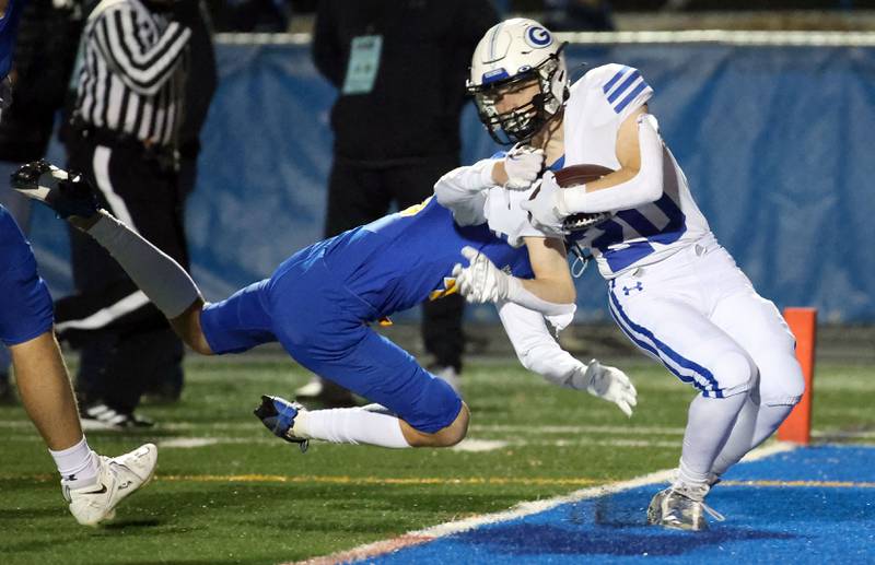 Geneva's Michael Rumoro (20) slides past Lake Forest's Aedan Cassidy (46) for a touchdown during the IHSA Class 6A playoff game Friday November 3, 2023 in Lake Forest.