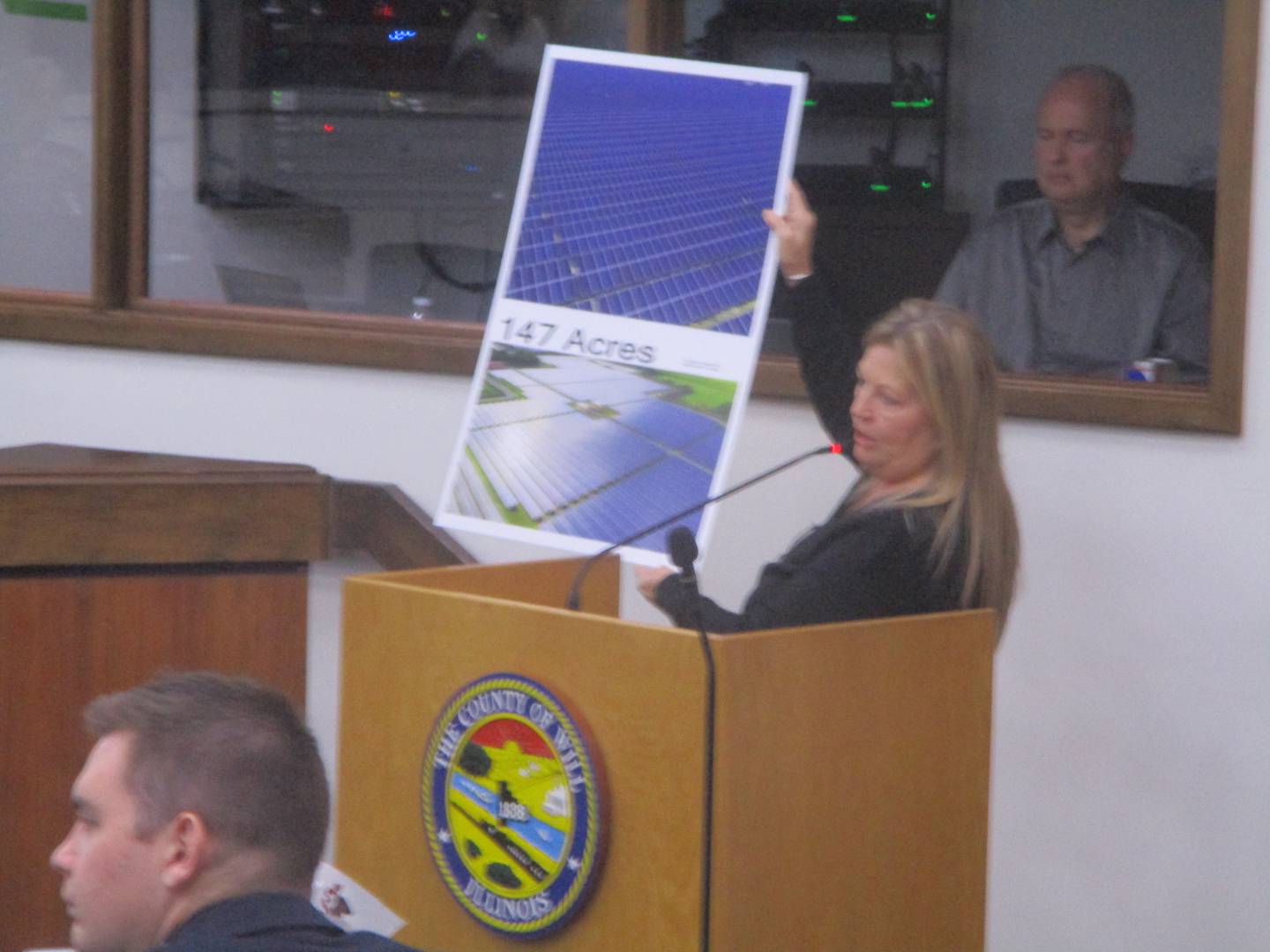 Wanda Alderson displays photographs of solar panels as she protests against the impact of the 3,600-acre solar project in southern Will County.