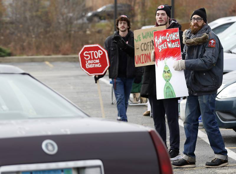 Mike Mueller, right, a Starbucks shift lead and a member of the union’s bargaining team, along with community members Ethan Buhrow, left, and Jayden Preusker picket Thursday, Nov. 17, 2022, at the Cary location on Starbucks' Red Cup Day. Workers at Starbucks in Cary joined other workers across the country seeking to convince the company to better negotiate with its unionized locations.