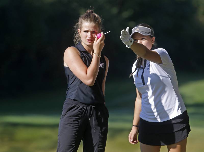 Prairie Ridge’s Lily Myers and Jacobs’ Kate Maurus talks about where to hit the ball on the 5th hole during the Fox Valley Conference Girls Golf Tournament Wednesday, Sept. 25, 2024, at Crystal Woods Golf Club in Woodstock.