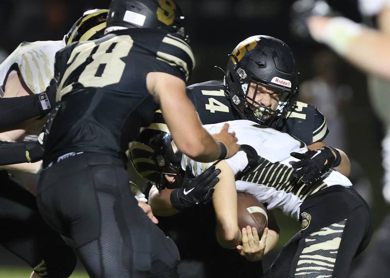 Sycamore's Ethan Bode (left) and Kiefer Tarnoki sack Oak Forest quarterback Luke Sparacino during their game Friday Sept. 2, 2022, at Sycamore High School.
