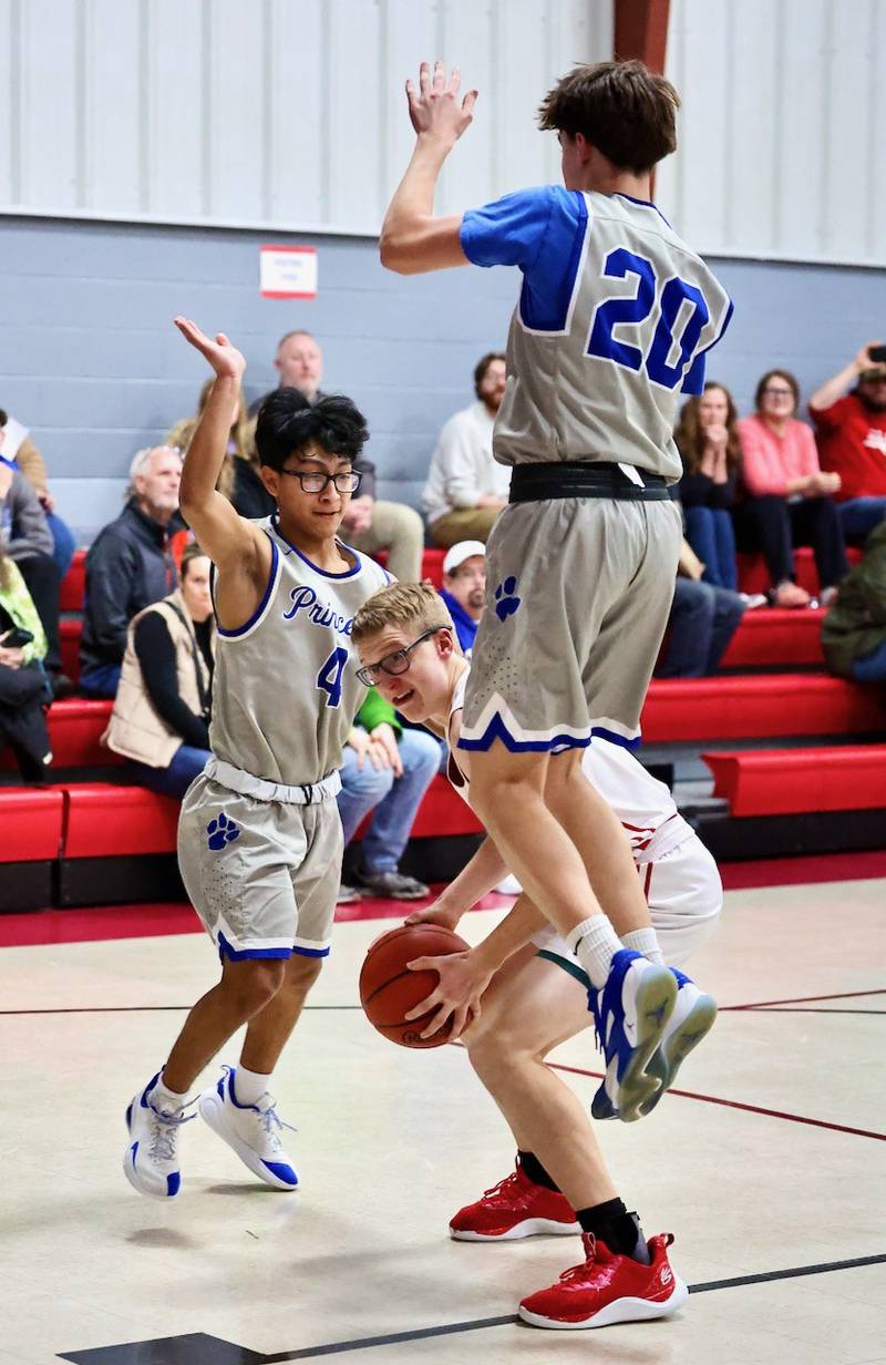 PCA's Trustin Crew gets Princeton's Brody Ross airborne while Michel Sanchez defends in Thursday's JV game at Howard Hoffman Memorial Gymnasium.