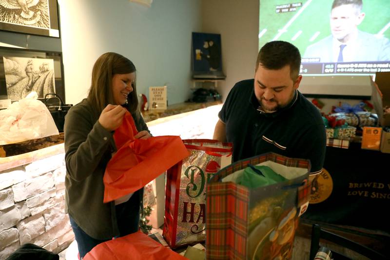 Jess Davis and Zach Davis wrap a gift during a gift wrapping party for clients of the Association for Individual Development (AID) hosted by the Batavia Rotary Club on Thursday, Dec. 12, 2024 at Brother Chimp Brewing in North Aurora.