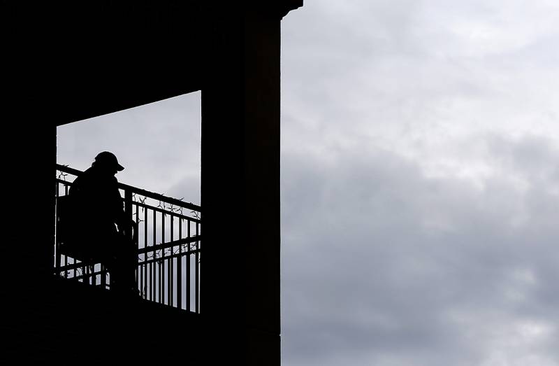 A man watches the McHenry ShamROCKS the Fox Festival Parade on Saturday, March 16, 2024, from his balcony along Green Street in McHenry.