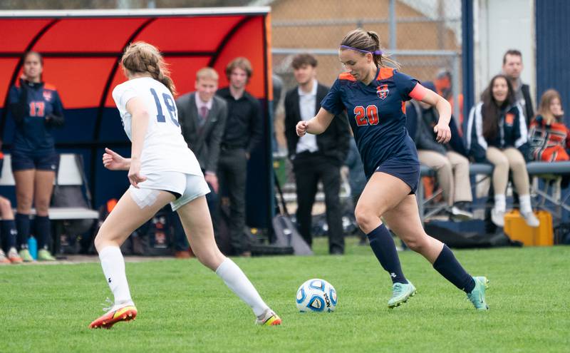 Oswego’s Anna Johnson (20) plays the ball against Oswego East's Morgan Dick (18) during a soccer match at Oswego High School on Monday, May 2, 2022.