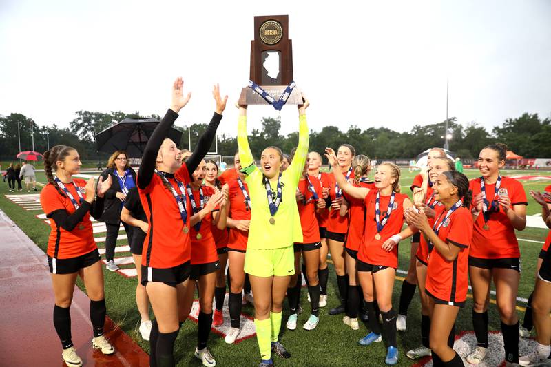Crystal Lake Central goal keeper Addison Cleary holds up the state championship trophy after their win over Triad in the Class 2A state championship game at North Central College in Naperville on Saturday, June 1, 2024.