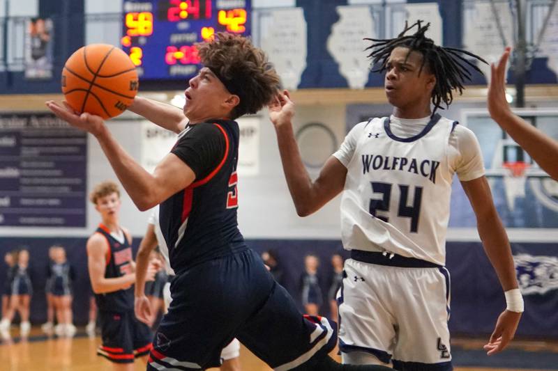 Oswego’s Mariano Velasco (5) drives to the hoop against Oswego East's Mason Lockett IV (24) during a basketball game at Oswego East High School on Saturday, January 14, 2017.