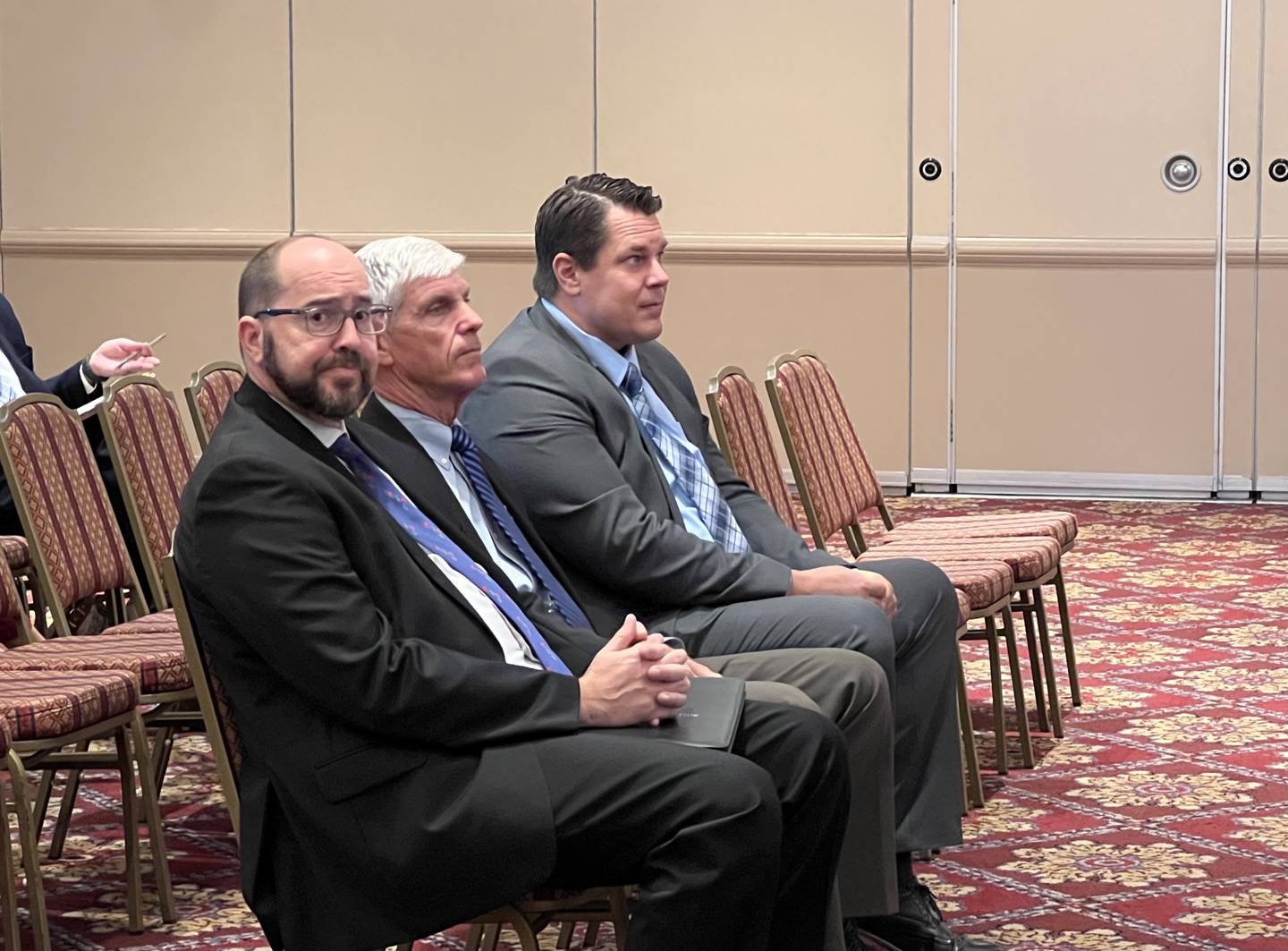 (From left) David Berault, Michael Roth and Brian Gregory sit in the front row during the July 27, 2023 Illinois Health Facilities and Services Review Board meeting in Bolingbrook.