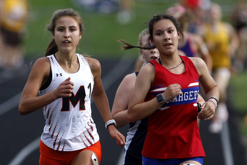 McHenry’s Danielle Jensen passes Dundee-Crown’s Sarah Hillyer on her way to winning the 3200 meter run on Thursday, May 2, 2024, during the Fox Valley Conference Girls Track and Field Meet at Jacobs High School in Algonquin.