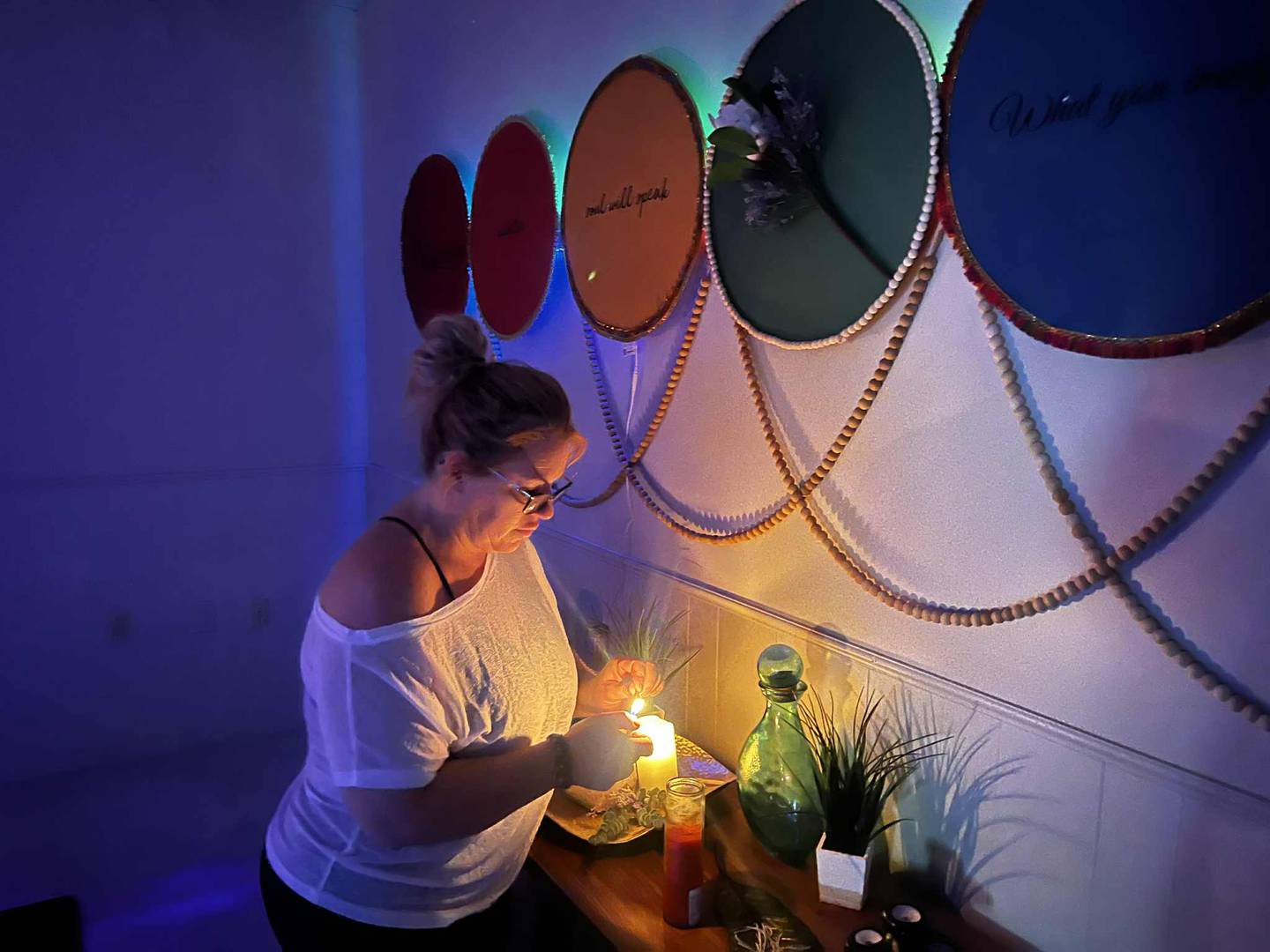 Amber Hoffman lights a candle inside the Zen Room at Elevate Studio in Sterling.