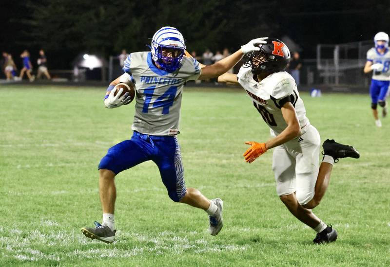 Princeton's Jack Oester stiff arms a Kewanee defender Friday at Bryant Field. The Tigers won 63-12.