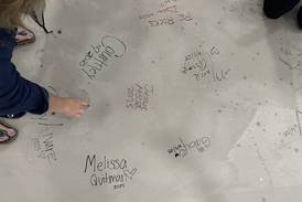 Staff at Joliet’s Gompers Jr. High leave mark on new gym floor