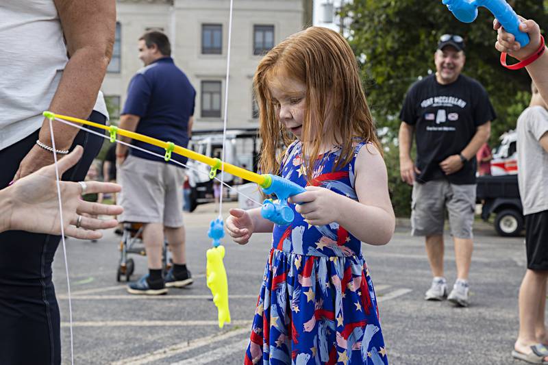 Mariah Wolf, 4, of Dixon hauls herself in quite a catch Friday, June 30, 2023 during game at Family Fun Night in Dixon. The annual Family Fun Night near the old Lee County Courthouse kicked off Petunia Fest with an ice cream social, games for the kids, a touch-a-truck and music by the Dixon Municipal Band.
