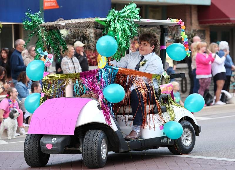 The Sycamore High School dance and football golf cart drives down State Street Wednesday, Oct. 5, 2022, during the school's homecoming parade.