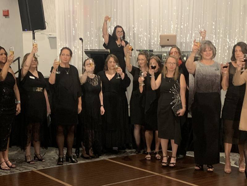 Jen Gibson, back row, CASA of McHenry County's events and communications manager, leads attendees of the agency's Little Black Dress event in a toast on Oct. 10, 2024.