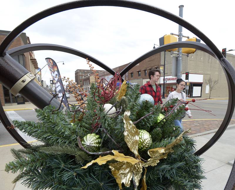 Shoppers pass one of the Christmas displays Saturday during Streator’s Mistletoe Market Saturday .