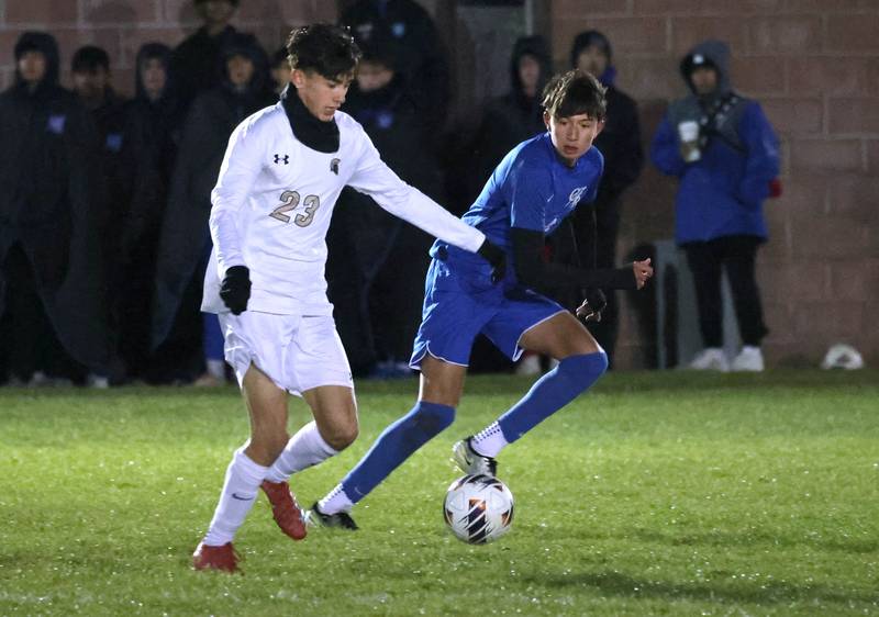 Sycamore's Leo Padilla (left) pushes the ball ahead of Burlington Central’s Ethan Domaleczny Tuesday, Oct. 21, 2025, during their IHSA Class 2A regional semifinal match at Burlington Central High School.