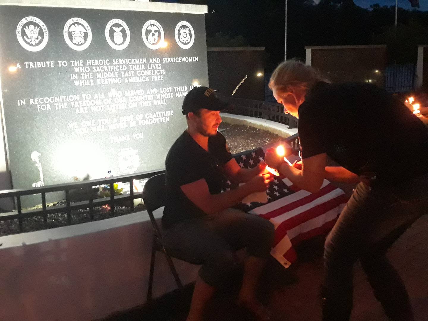Sarah Lee shares her candlelight Saturday, Aug. 13, 2022, during a vigil at the Middle East Conflicts Wall in Marseilles. The Waypoint Vets of the Nashville, Tennessee area, visited the memorial.