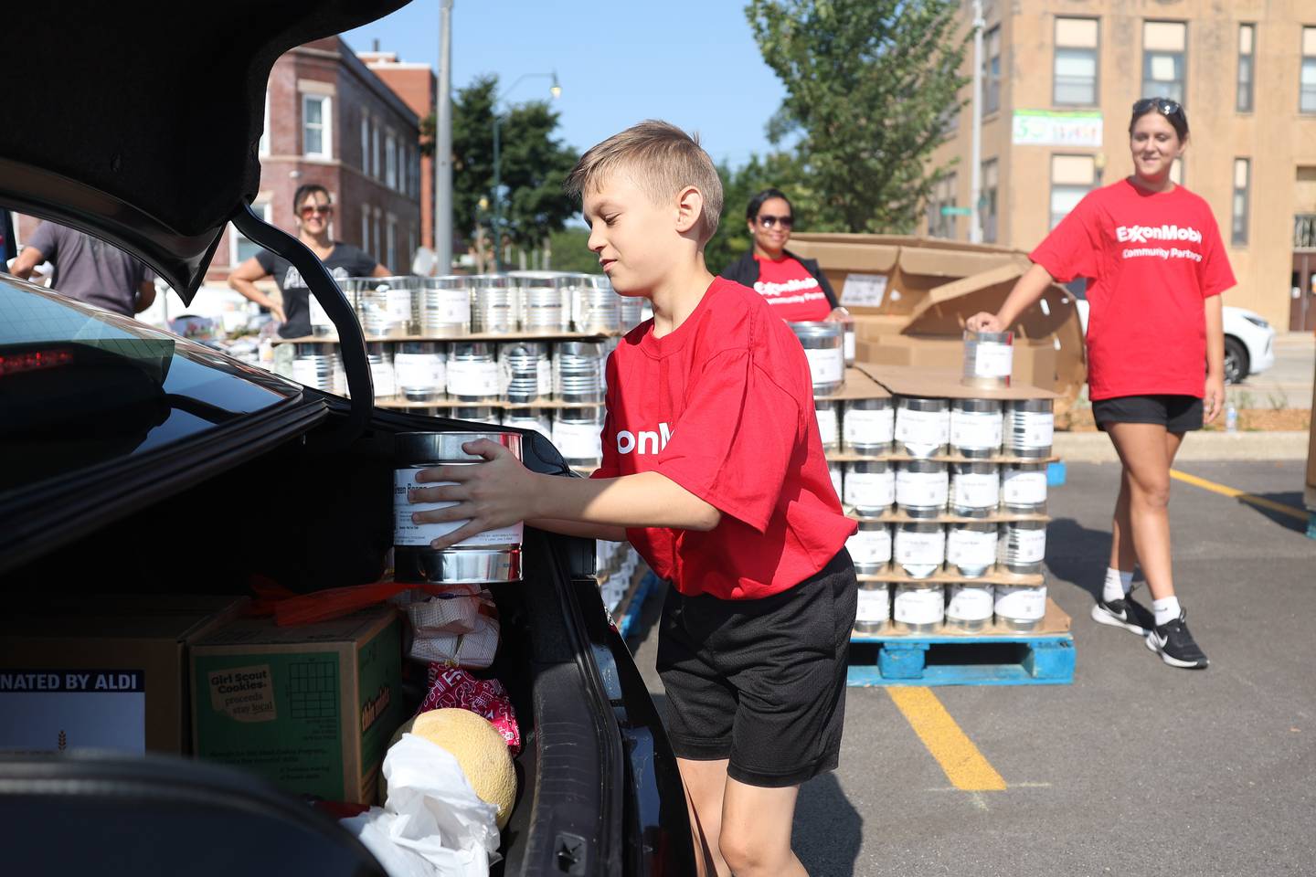 Damian Colarelli loads a can of beans into a trunk outside the Will County Office Building on Saturday, July 27, 2024 in Joliet. Will County and the city of Joliet partnered with ShareFest Will County to give out food and gift cards to help with recovery from last week’s severe storms.